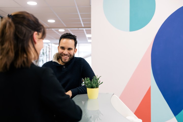 Collègues souriants en train d'avoir une conversation